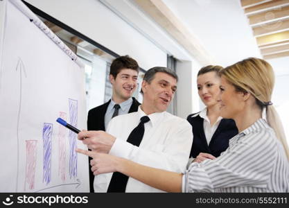 Senior male business man giving a presentation at a meeting at modern light office on a table board