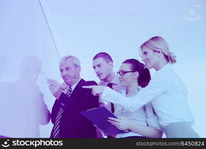 Senior male business man giving a presentation at a meeting at modern light office on a table board