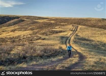 senior male cyclist is riding a gravel bike on a trail in Colorado foothills in early spring scenery, Soapstone Prairie Natural Area