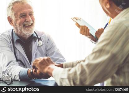 Senior male doctor talking to elder man patient in the hospital office. Medical healthcare and doctor staff service concept.. Senior doctor talking to patient in the hospital.