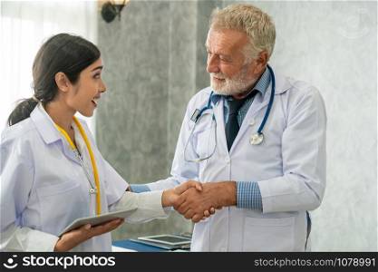 Senior male doctor working with another doctor in hospital. Concept of medical healthcare and doctor staff education.