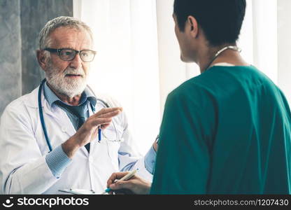 Senior male doctor working with another doctor in hospital. Concept of medical healthcare and doctor staff education.. Senior male doctor working with another doctor.