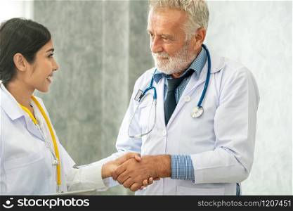 Senior male doctor working with another doctor in hospital. Concept of medical healthcare and doctor staff education.