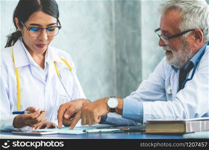 Senior male doctor working with another doctor in hospital. Concept of medical healthcare and doctor staff education.. Senior male doctor working with another doctor.
