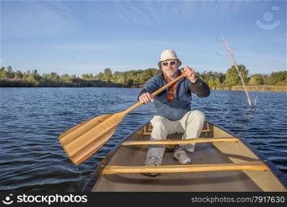 senior male enjoying morning sun on a lake in a canoe, Riverbend Ponds Natural Area, Fort Collins, Colorado