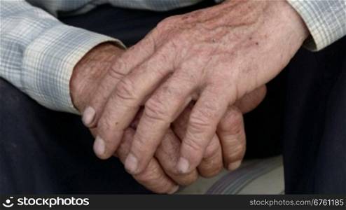 Senior male hands with scraped knuckles and chipped black nails