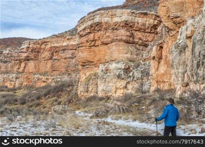 senior male hiking in sandstone canyon in winter, Red Mountain Open Space near Fort Collins, Colorado