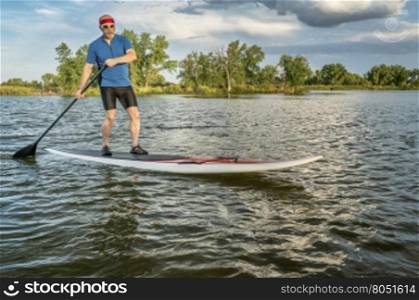 senior male on stand up paddleboard on a lake in northern Colorado