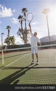 Senior male tennis player playing on court