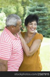 Senior man and a mature woman standing together in a garden