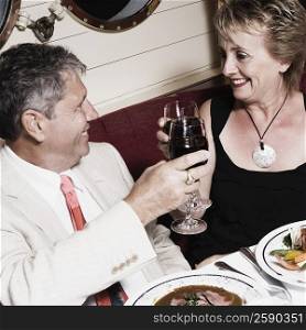 Senior man and a mature woman toasting with wine glasses