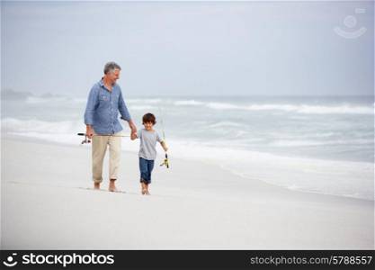 Senior man and grandson walking on beach