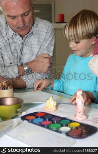 Senior man and little boy drawing