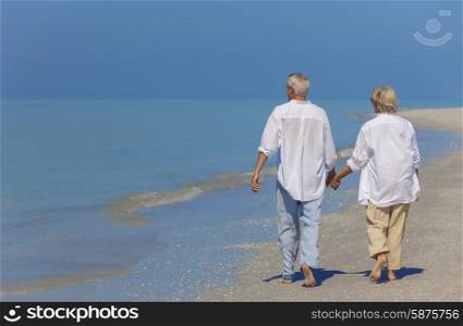 Senior man and woman couple holding hands walking on a deserted beach