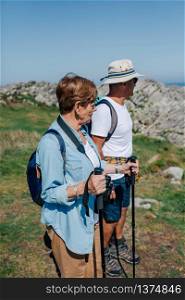 Senior man and woman practicing trekking outdoors. Senior couple practicing trekking outdoors
