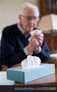 Senior Man At Home Suffering With Cold Or Flu Virus
