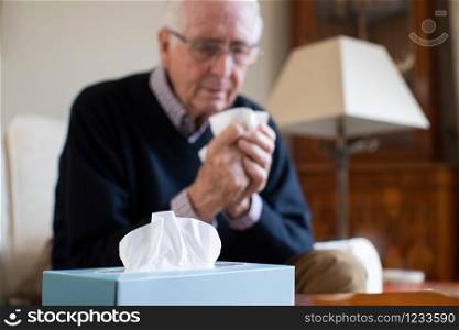 Senior Man At Home Suffering With Cold Or Flu Virus