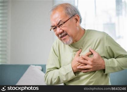 Senior man bad pain hand touching chest having heart attack, Asian older man have congenital disease suffering from heartache alone at home his heart aches, Old age retirement health problems diseases