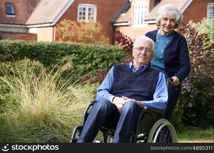 Senior Man Being Pushed By Wife In Wheelchair
