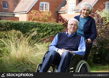 Senior Man Being Pushed By Wife In Wheelchair