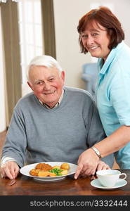 Senior Man Being Served Meal By Carer