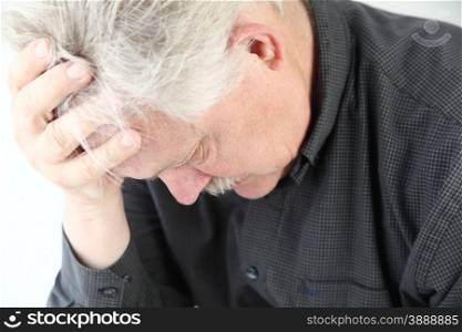 senior man bent over with grief or depression