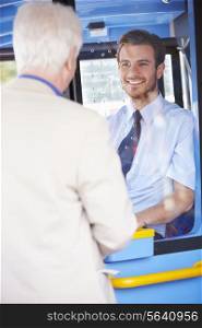 Senior Man Boarding Bus And Buying Ticket