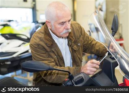 senior man buying new scooter in store