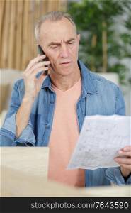 senior man calculating taxes at home