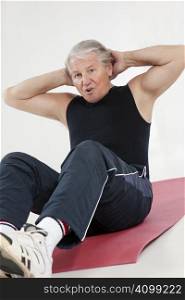 senior man doing abs exercise in health club