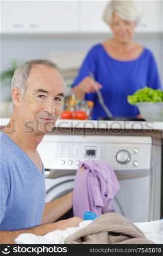 senior man doing laundry at home