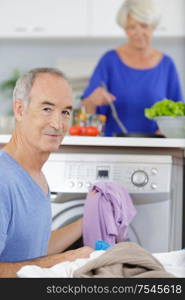 senior man doing laundry at home