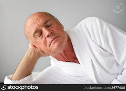 Senior man dozing in a bathrobe