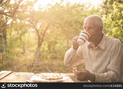 senior man drinking a tea at the garden