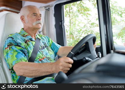 senior man driving a camper van