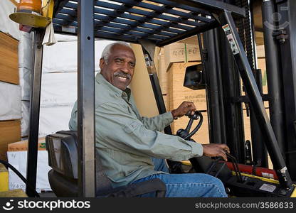 Senior man driving forklift truck