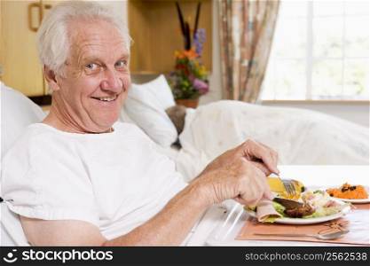 Senior Man Eating Hospital Food In Bad