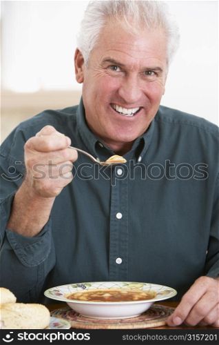 Senior Man Eating Soup, Smiling At The Camera