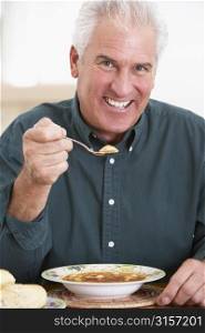 Senior Man Eating Soup, Smiling At The Camera