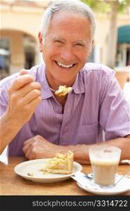 Senior Man Enjoying Coffee And Cake In CafZ