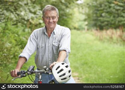 Senior Man Enjoying Cycle Ride In The Countryside