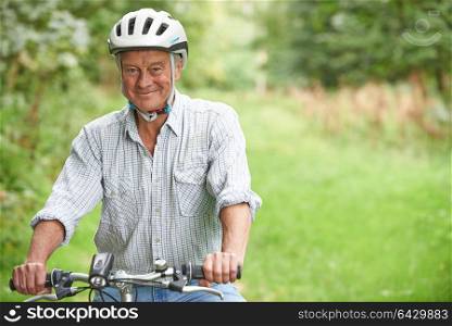 Senior Man Enjoying Cycle Ride In The Countryside