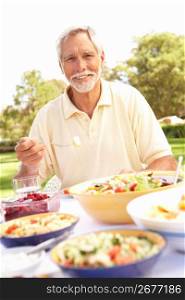 Senior Man Enjoying Meal In Garden