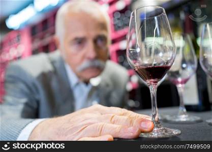 senior man enjoys drinking wine