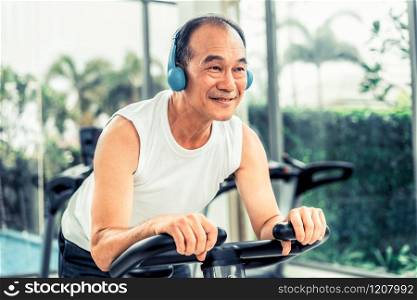 Senior man exercise on cycling machine in fitness center. Mature healthy lifestyle.. Senior man exercise on cycling machine in fitness center