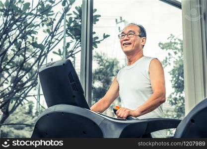 Senior man exercise on treadmill in fitness center. Mature healthy lifestyle.. Senior man exercise on treadmill in fitness center