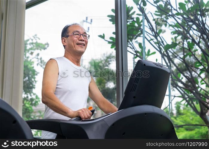 Senior man exercise on treadmill in fitness center. Mature healthy lifestyle.