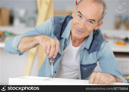 senior man fixing a furniture