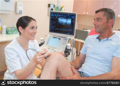 senior man getting ultrasound scan on knee