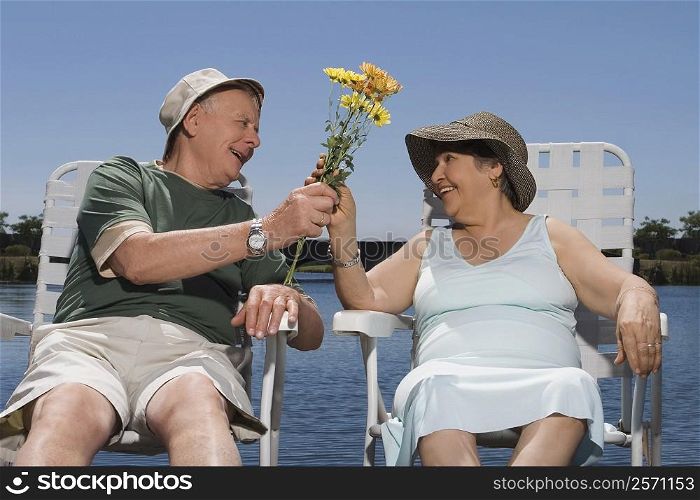 Senior man giving a bunch of flowers to a senior woman